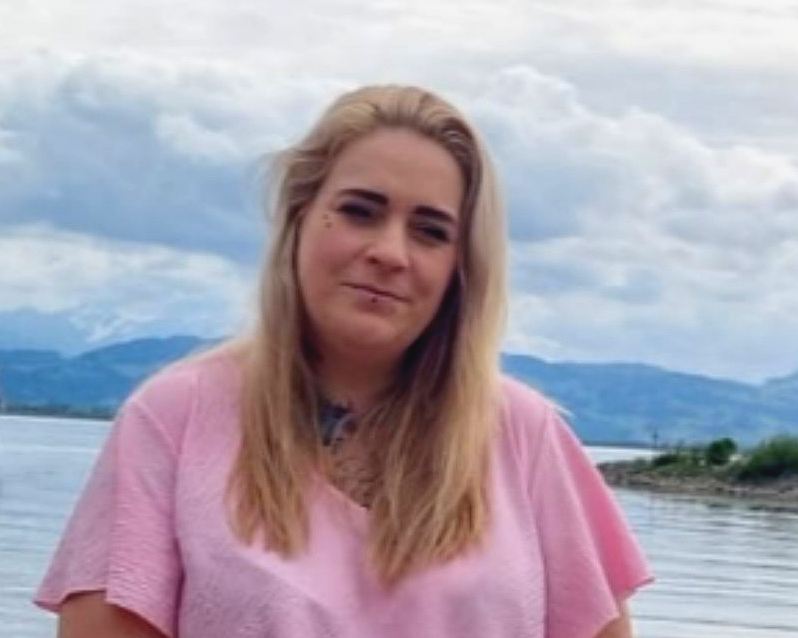 Sandra Lutz, Tagesmutter der Rasselbande, lächelnd vor einem See mit Bergen im Hintergrund